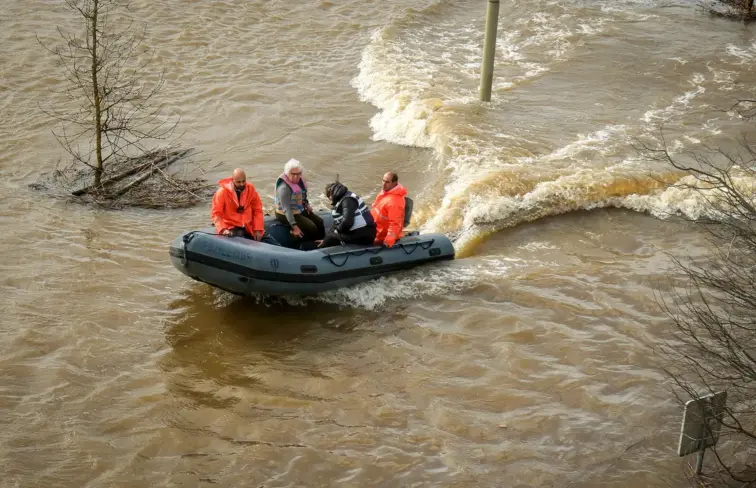 Pessoas num barco de resgate no meio das cheias em Alcácer do Sal.